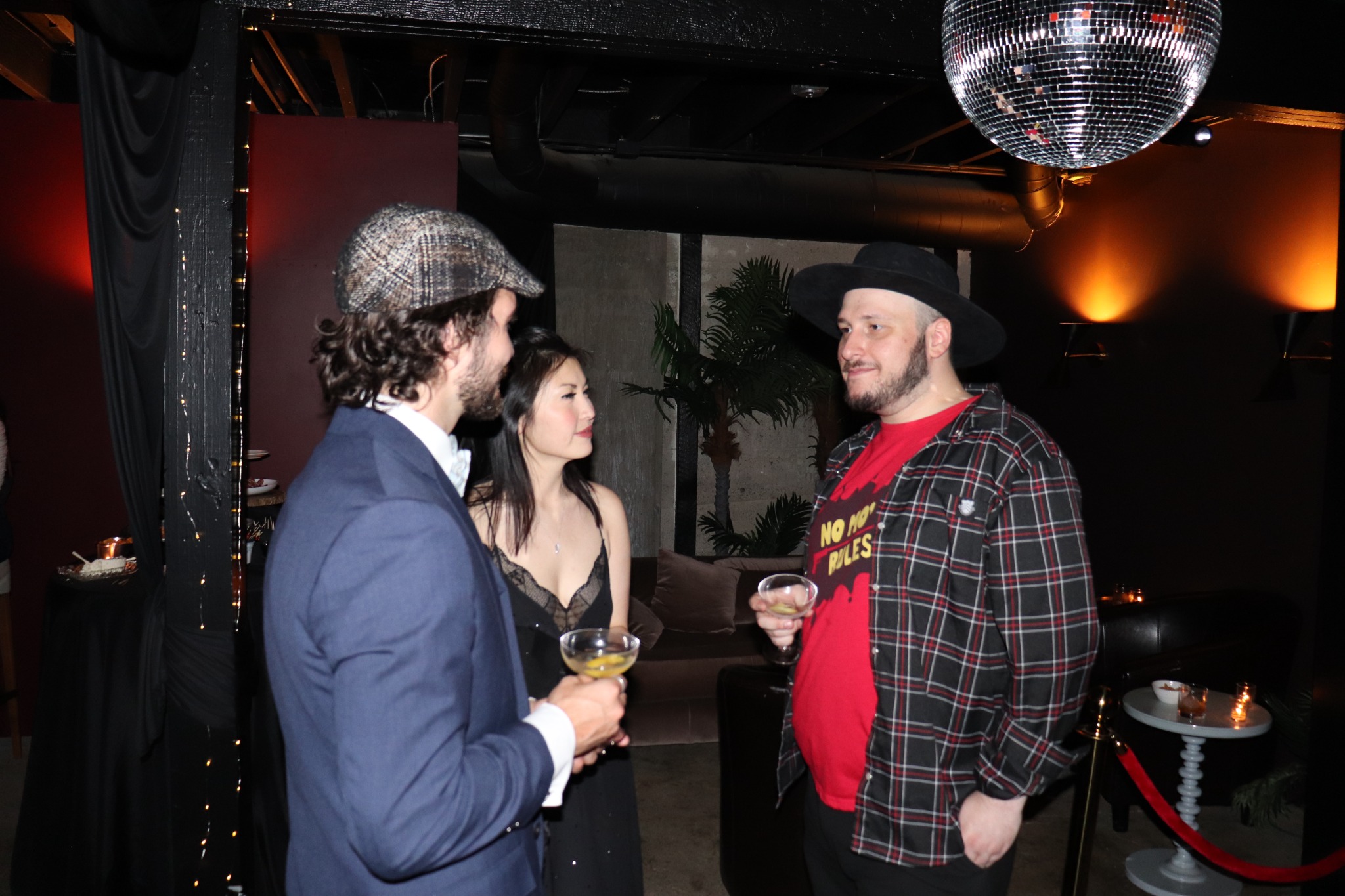 Three guests in conversation beneath a disco ball